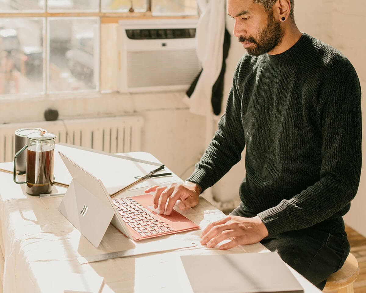 A small-business owner replying to customer emails on a laptop