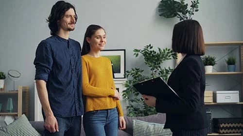 A letting agent showing a couple around a property